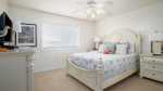 Spacious guest bedroom with comfortable queen bed and ceiling fan